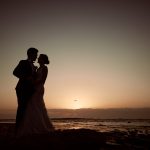 Bride and groom silhouette at sunrise during their Long Reef wedding