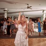 Emma tossing her wedding bouquet to guests at Palm Beach Golf Club reception